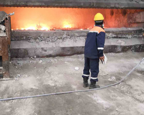 aluminum casting furnace operation with worker monitoring molten aluminum